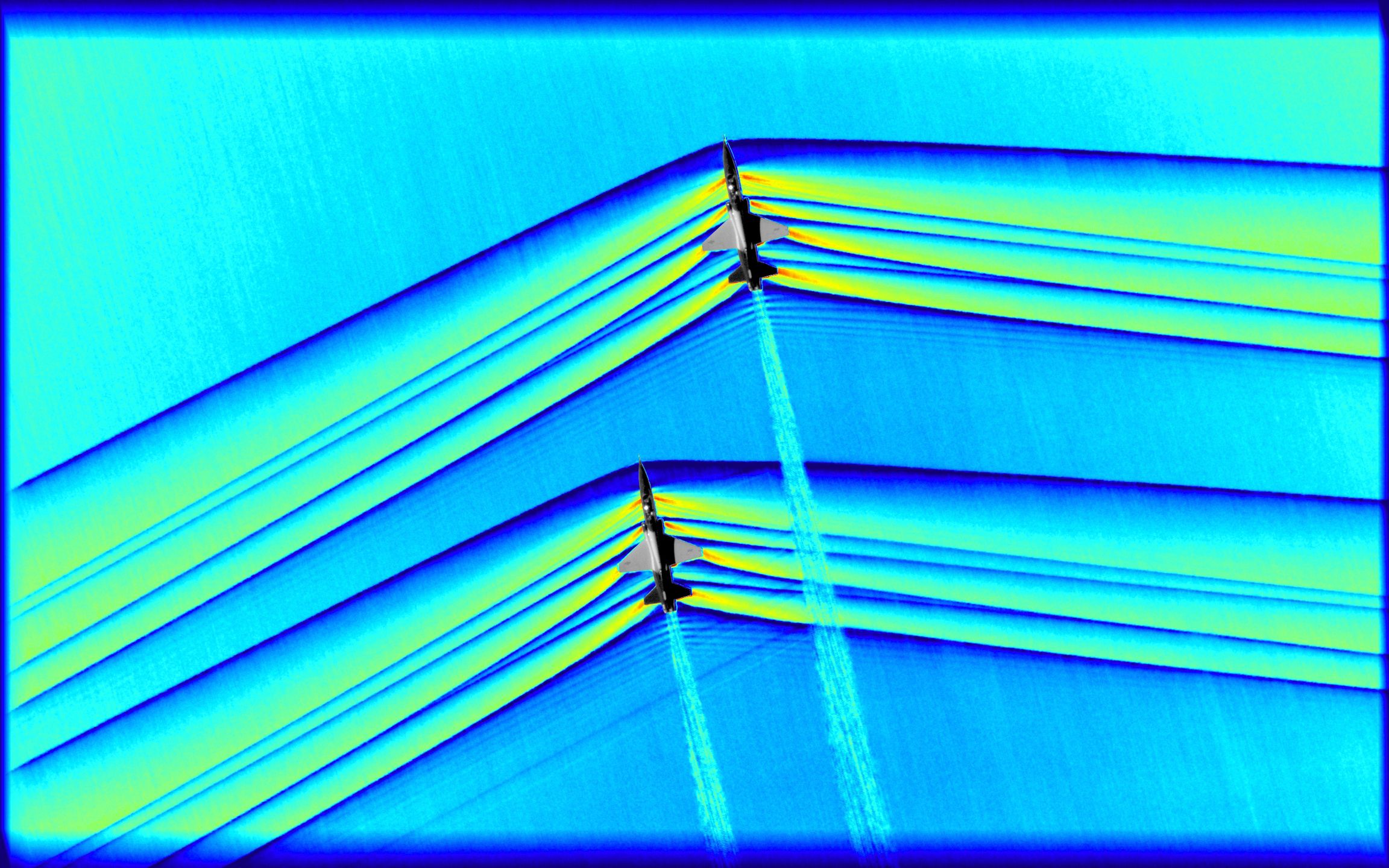 NASA. Dwa samoloty T-38 lecące w formacji, odległość między nimi wynosi 10 metrów. Zdjęcie zostało pokolorowane w palecie RGB, by podkreślić intensywność ściskania powietrza. 