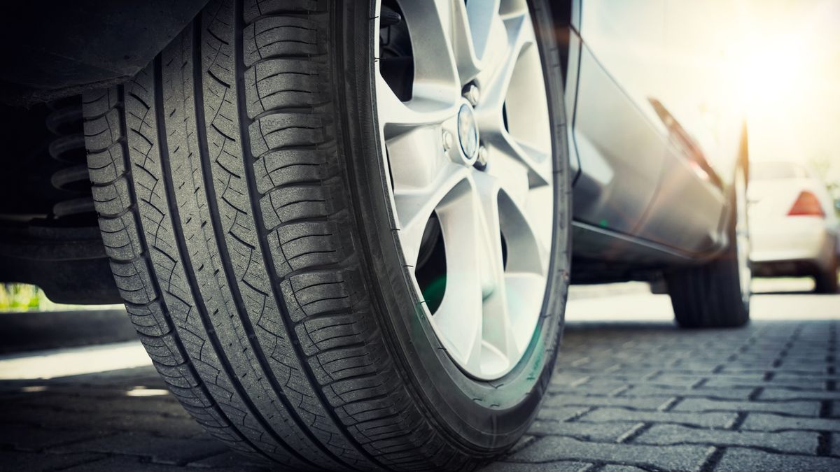 Car all-season tire close up, parked car. Low angle shot, wheel auto with aluminum rim concept