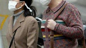 W ochronnych maskach na chińskiej ulicy (Fot. AFP)