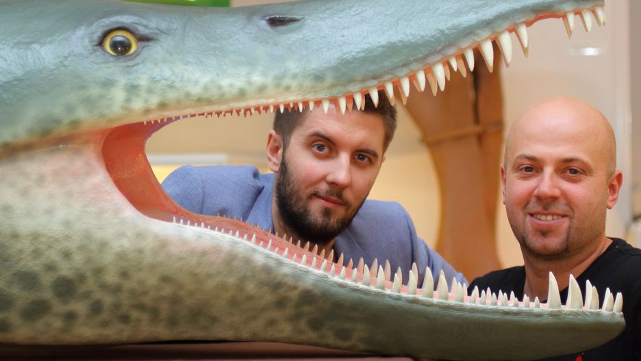 Dr Daniel Tyborowski (z lewej) i dr hab. Błażej Błażejowski (z prawej) prezentują rekonstrukcję głowy olbrzymiego pliozaura z Krzyżanowic