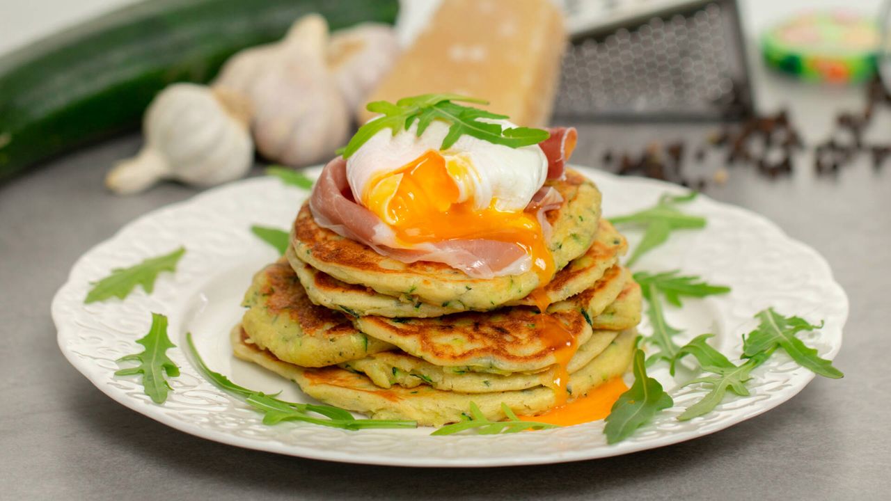 Mastering the art of savory zucchini pancakes with poached eggs and Parma ham