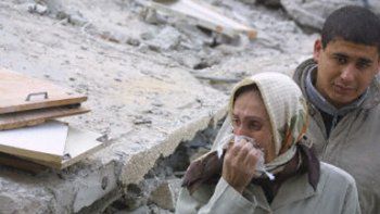 Kobieta rozpacza nad zburzonym domem