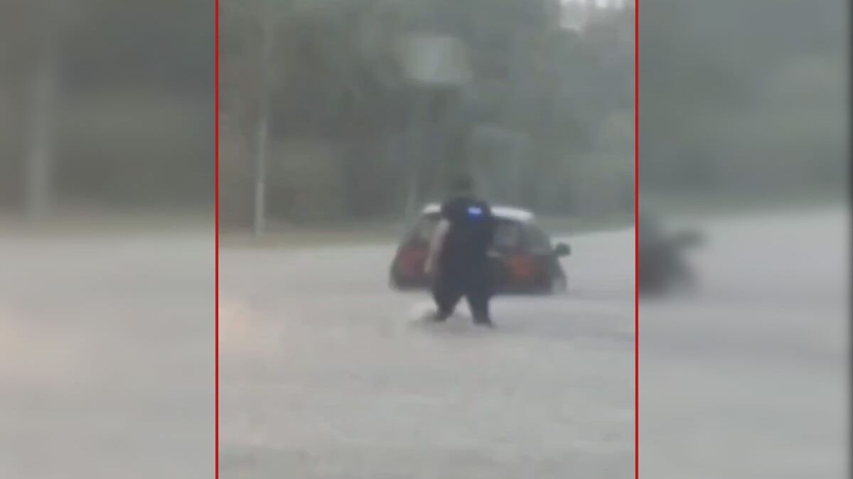 Policjant ratuje kobietę z auta na drodze