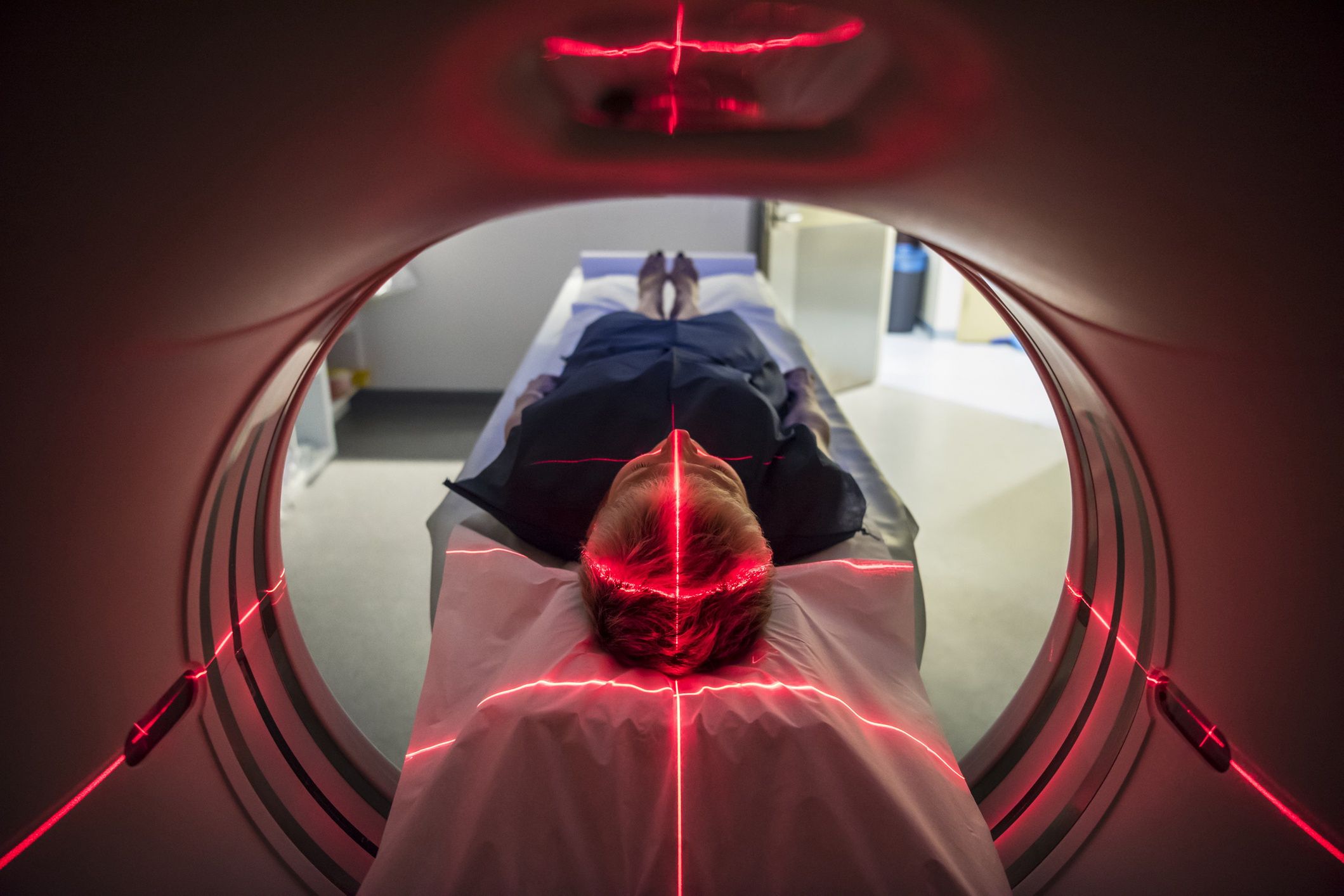 Patient lying inside a medical scanner in hospitalPerson undergoing a CAT scan in hospital. PET scan equipment. Medical CT scan of patient.JohnnyGreigAnatomy, Diagnostic Medical Tool, Glowing, Medical Scanner, Medical Scan, Medical Procedure, Ominous, Lighting Equipment, Examination Gown, PET Scan, PET Scan Machine, Medical Exam, CAT Scan, Adult, Symmetry, Lying Down, MRI Scanner, X-ray, Biology, One Person, Illuminated, Expertise, Accuracy, Discovery, Exploration, Care, Cross Shape, Red, Modern, Below, Healthcare And Medicine, Technology, Science, X-ray Image, MRI Scan, Indoors, Horizontal, Unusual Angle, Human Head, Human Brain, Human Skull, The Human Body, Illness, Patient, People, Sydney, Australia, Hospital, Musical Instrument, CAT Scan Machine, Medical Equipment, Equipment, Machinery, PitchAUS2015, LypseAUS2015