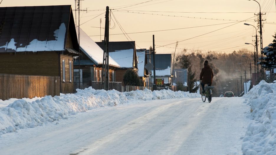 FLPA initial hard drive July 2013Cyclist on snow covered road, traditional wooden houses and piles of cleared snow, Bialowieza Village, Podlaskie Voivodeship, Poland, februaryFLPA/Robert Canis