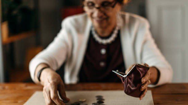 Old woman counting coins from her wallet