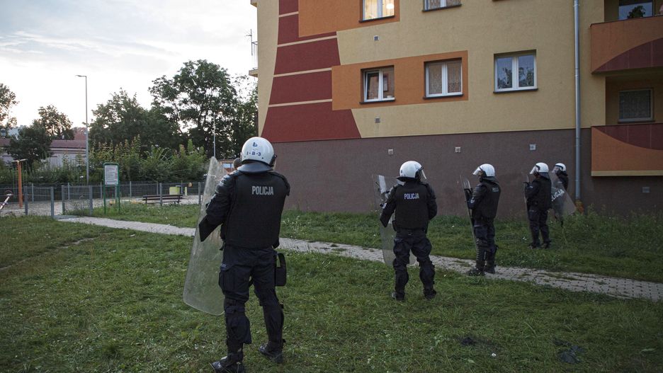 Lubin, 08.08.2021. Policja podczas protestu przed Komendą Powiatową Policji na ul. Traugutta w Lubinie, 8 bm. W piątek 6 bm. policjanci interweniowali w sprawie mężczyzny, który miał być pod wpływem narkotyków i rzucać w okna mieszkańców kamieniami. Policjanci po przybyciu go obezwładnili. Protestujący uważają że mężczyzna zmarł podczas interwencji. (aldg) PAP/Aleksander Koźmiński