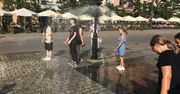 Kraków: Upał rozlewa się po mieście. Zraszacz na Rynku Głównym przyciąga spragnionych ochłody