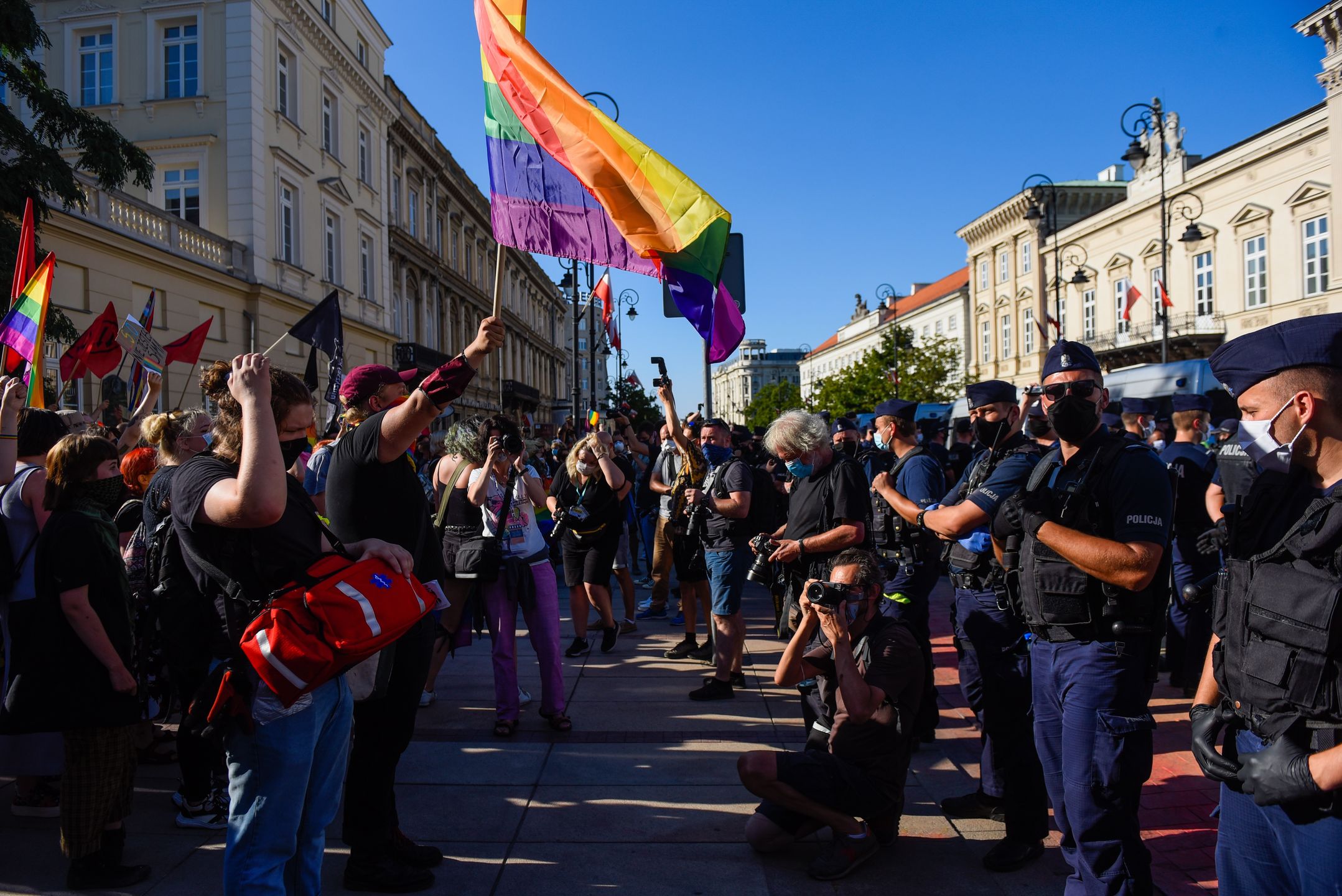 WARSAW, POLAND - AUGUST 16: LGBT activists hold banners during a counter protest against an anti-LGBT far right rally on August 16, 2020 in Warsaw, Poland. At the same time, a counter protest is happening on the other side of the street by pro-LGBT activists. After a homophobic speech against the LGBT community during Andrzej Duda's presidential campaign, several pro-LGBT actions by activists have taken place across the country. The far right has responded with condemnation, claiming LGBTQ ideology is worse than communism. (Photo by Omar Marques/Getty Images)
