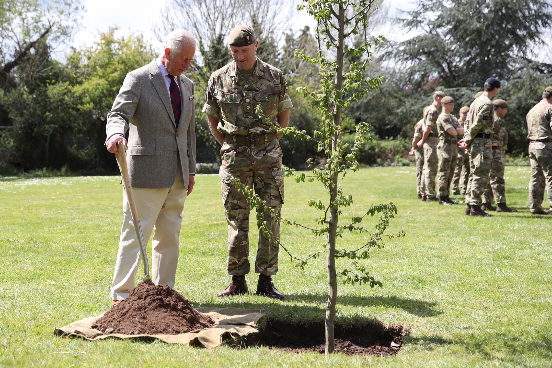 WINDSOR, ENGLAND - MAY 05: Prince Charles, Prince of Wales helps plant a tree next to Commanding Officer, Lieutenant Colonel Henry Llewelyn-Usher, during a visit to the Welsh Guards at Combermere Barracks on May 5, 2021 in Windsor, England. (Photo by Peter Cziborra - WPA Pool/Getty Images)