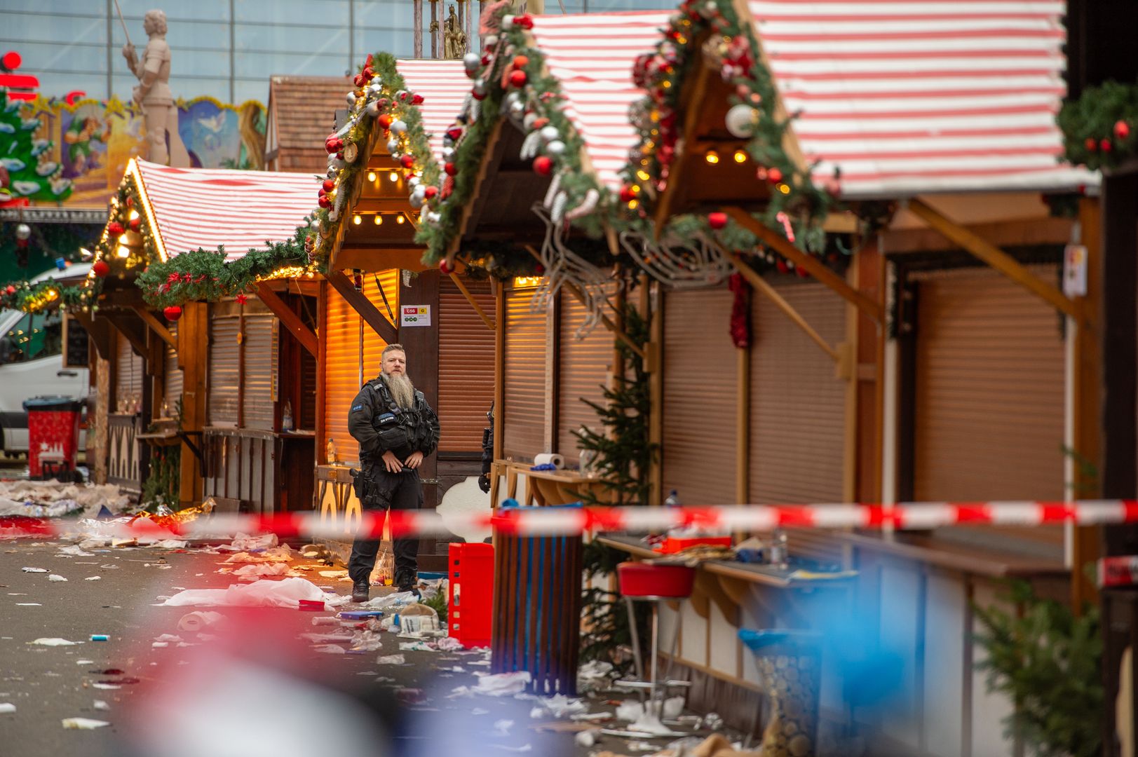MAGDEBURG, GERMANY - DECEMBER 21: A policeman stands protecting the crime scene of the shuttered Christmas market the day after a terror attack that has left five people dead, including a small child, and over 200 injured on December 21, 2024 in Magdeburg, Germany. Police arrested a man after he drove a black BMW past security obstacles and into the busy Christmas market in the early evening yesterday. The attacker is reportedly a Saudi national who has been living in Germany since 2006 and worked as a psychotherapist. In social media posts he was critical of Germany but also of Islam and the "Islamization" of Germany. He expressed support for policies of the far-right Alternative for Germany (AfD). (Photo by Craig Stennett/Getty Images)