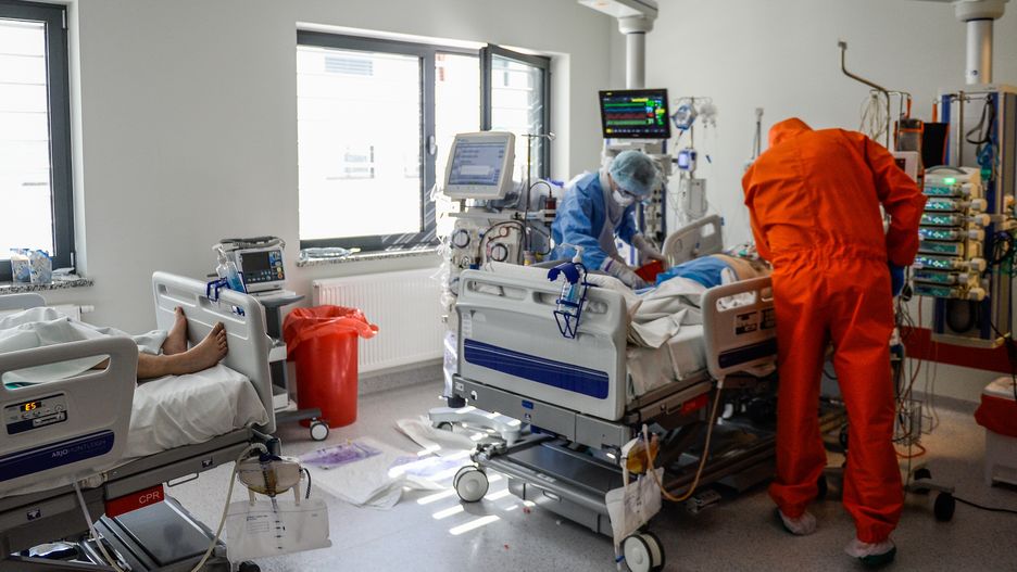 KRAKOW, POLAND - APRIL 18: Doctors wear protective, suits, masks, goggles and gloves as they perform a medical procedure in the femoral artery of a COVID - 19 patient inside the Intensive Care Unit (ICU) for COVID -19 patients of Krakow's University Hospital on April 18, 2020 in Krakow, Poland. Considered the largest and most modern medical centre in Poland, Krakow University Hospital is one of the designated hospitals to treat COVID-19 patients by the government. For the moment, 150 coronavirus patients are in the hospital and a total of 925 beds are available for future cases. From April 20, Poland will begin to gradually remove certain restrictions introduced in the wake of the COVID-19 epidemic. The country is approaching 10,000 confirmed COVID-19 cases and several hundred deaths. (Photo by Omar Marques/Getty Images)
