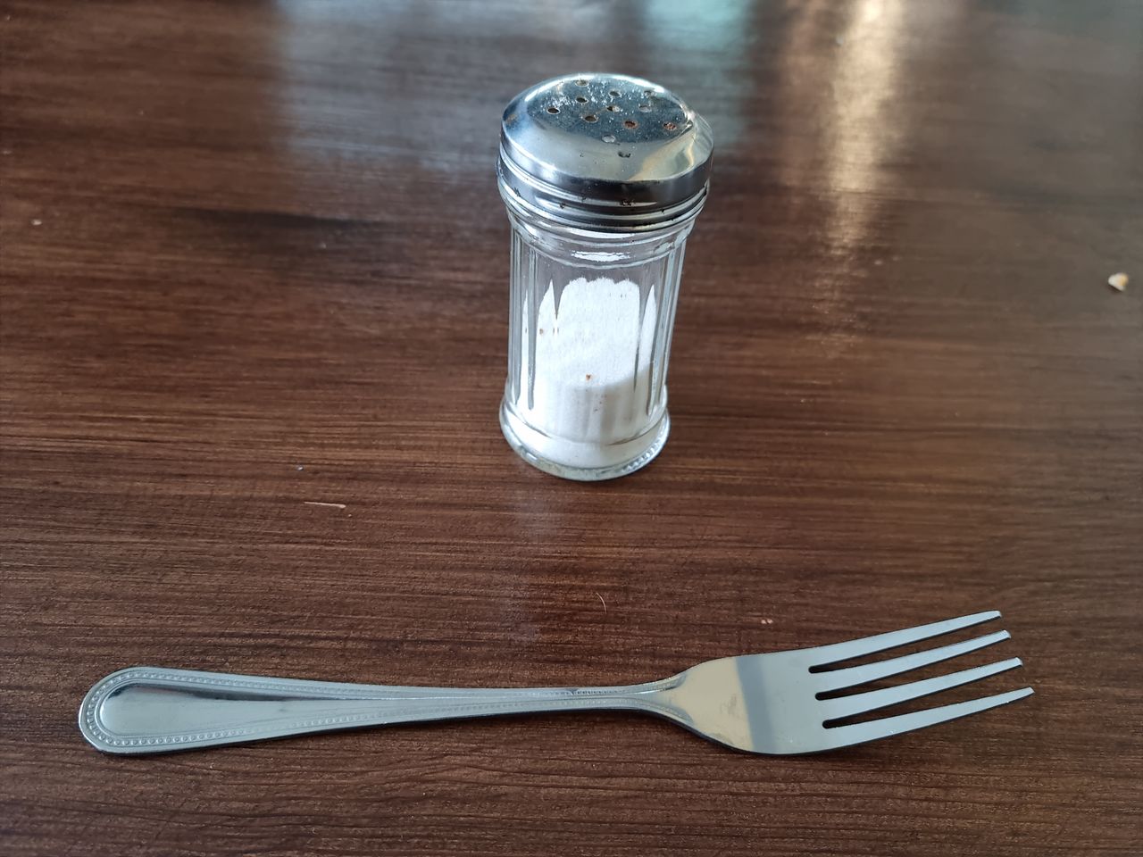 Sól w solniczce na stole, obok widelca