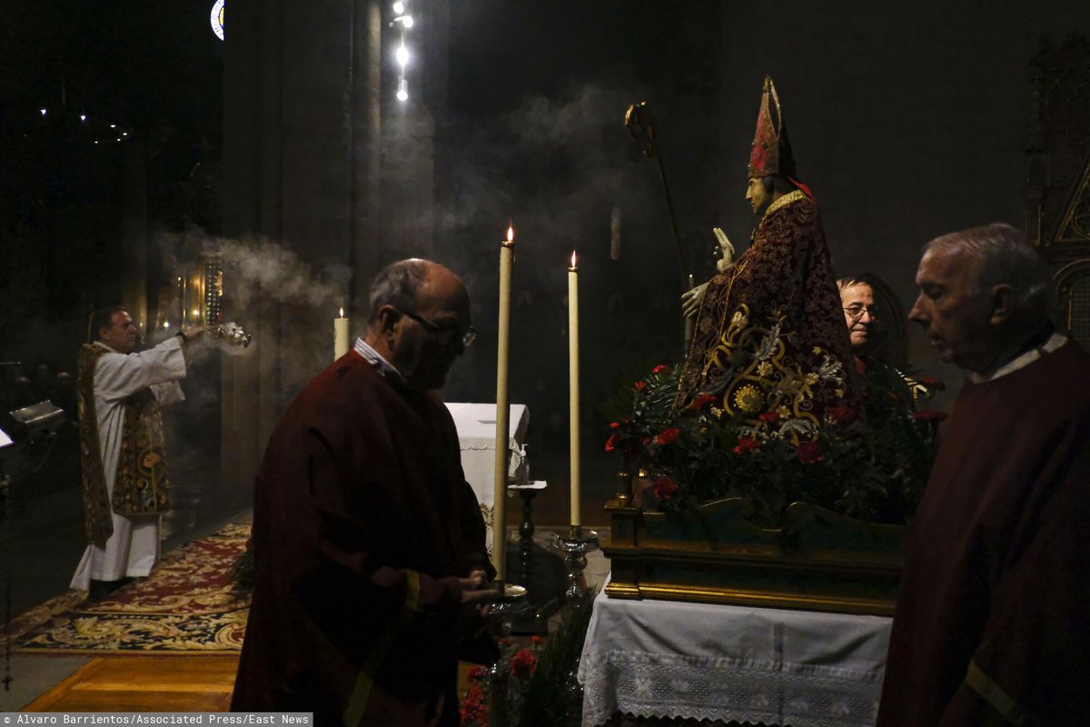 Ksiądz błogosławi posąg św. Blasa w kościele św. Mikołaja w północnej Hiszpanii