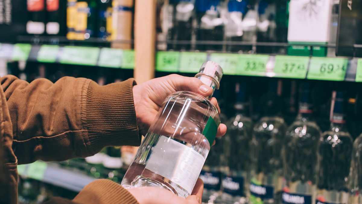 A male shopper in a supermarket holds a bottle of vodka in his hands.
A male shopper in a supermarket holds a bottle of vodka in his hands
Sergey Cherevko