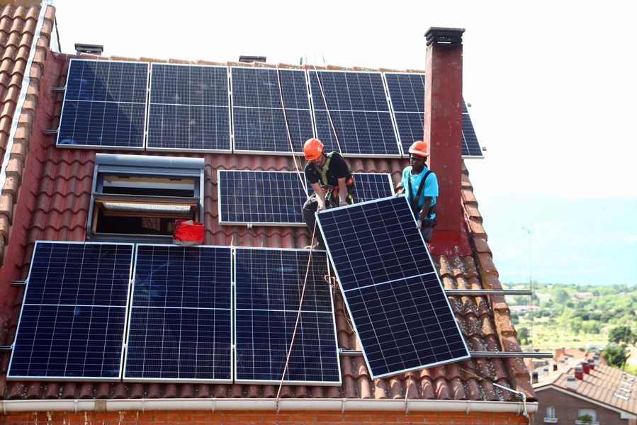 Rodrigue Kauahou and Jose Carlos Navarro, workers of the installation company Alromar, set up solar panels on the roof of a home in Colmenar Viejo, Spain, June 19, 2020. Picture taken June 19, 2020.