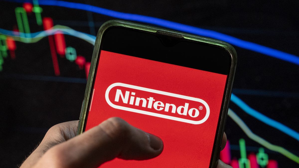 CHINA - 2021/12/09: In this photo illustration the Japanese multinational video gaming brand created and owned Nintendo logo seen displayed on a smartphone with an economic stock exchange index graph in the background. (Photo Illustration by Budrul Chukrut/SOPA Images/LightRocket via Getty Images)