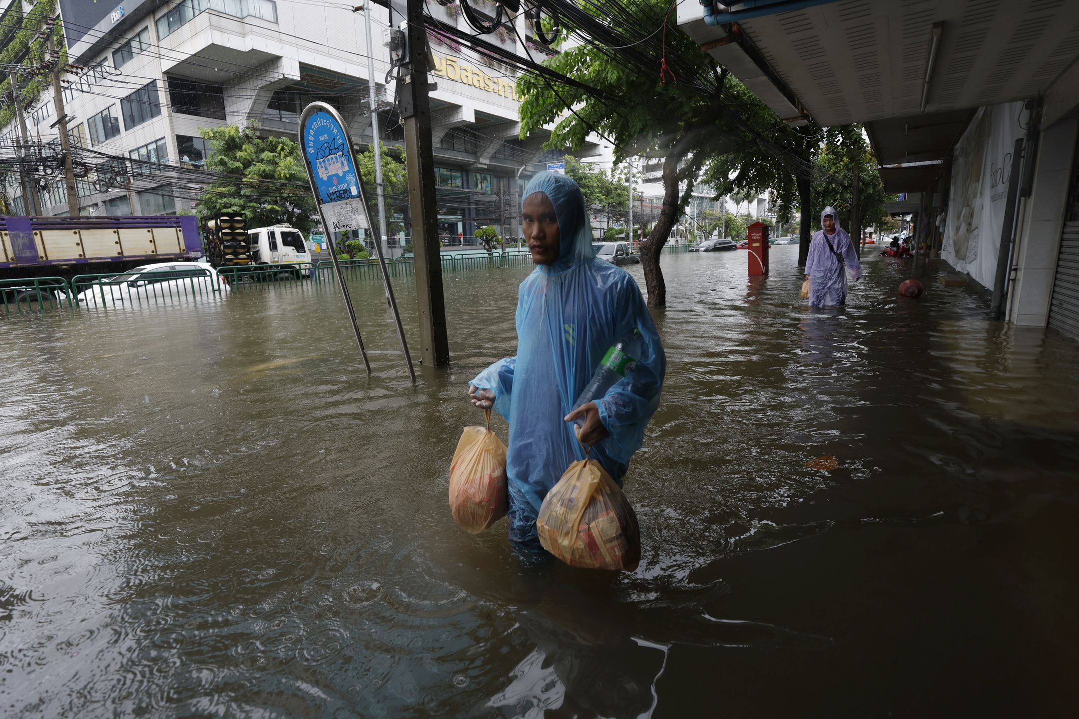 A resident carries food wades through floodwater during a downpour on a flooded major street, Phetchaburi Road in Bangkok, Thailand, 26 September 2026. All 50 districts in Bangkok have been declared flood disaster zones following the non-stop heavy downpour caused by a strong low-pressure system combined with seasonal monsoon patterns. EPA/RUNGROJ YONGRIT Dostawca: PAP/EPA.