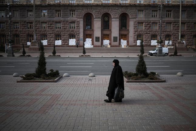 Kobieta przechodząca przed siedzibą mera Kijowa.