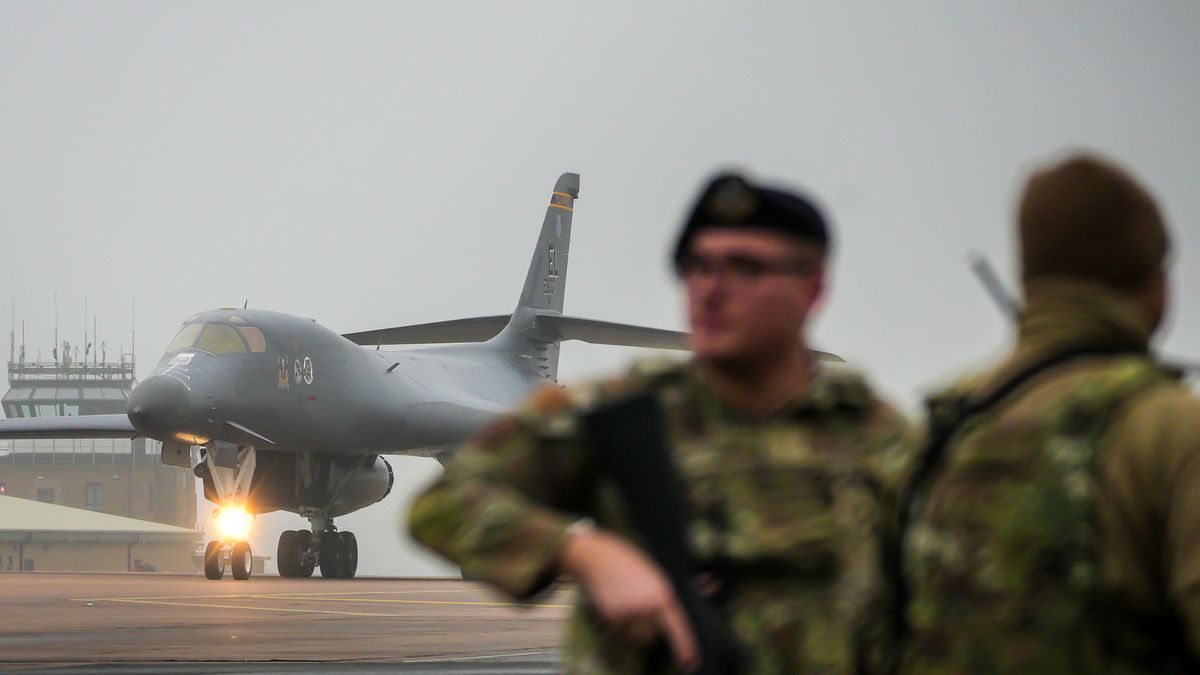 FAIRFORD, ENGLAND - MARCH 07: An armed airmen of the US Air Force guards the perimeter fence at RAF Fairford as a B1 Lancer bomber lands on March 07, 2026 in Fairford, England. Prime Minister Keir Starmer is allowing the US to use British bases, including RAF Fairford and Diego Garcia, to launch "defensive" strikes against Iranian missile sites while stating the UK would not join "offensive" combat. On Thursday Starmer announced that the UK is deploying four additional Typhoon fighter jets to Qatar, "to strengthen our defensive operations in Qatar and across the region." (Photo by Christopher Furlong/Getty Images)