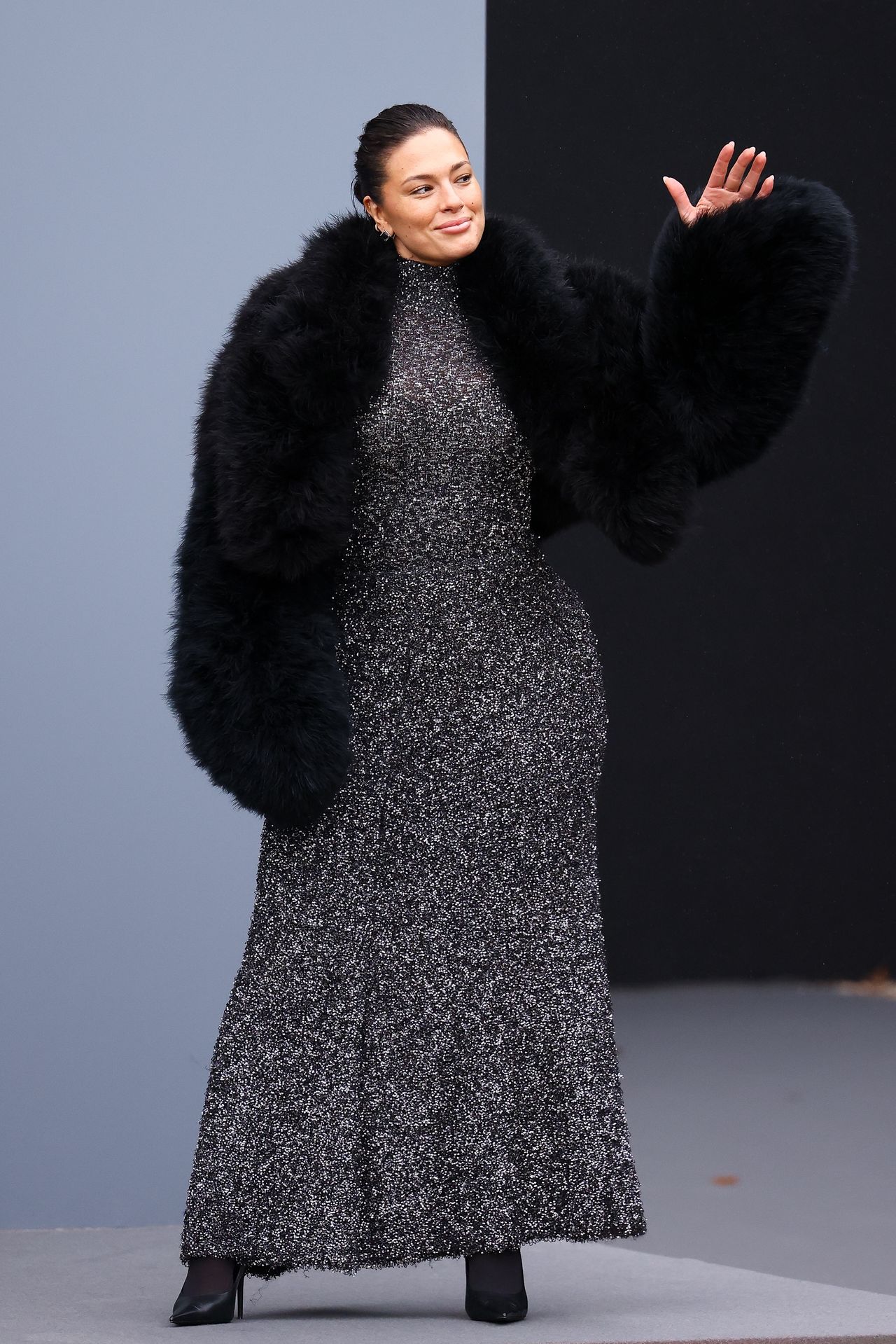 Ashley Graham at Fashion Week in a maxi dress and fur jacket