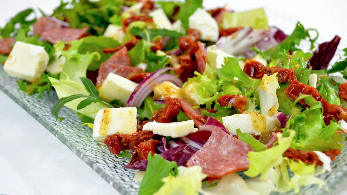 Sałatka z mixem sałat, salami, suszonymi pomidorami i mozzarellą