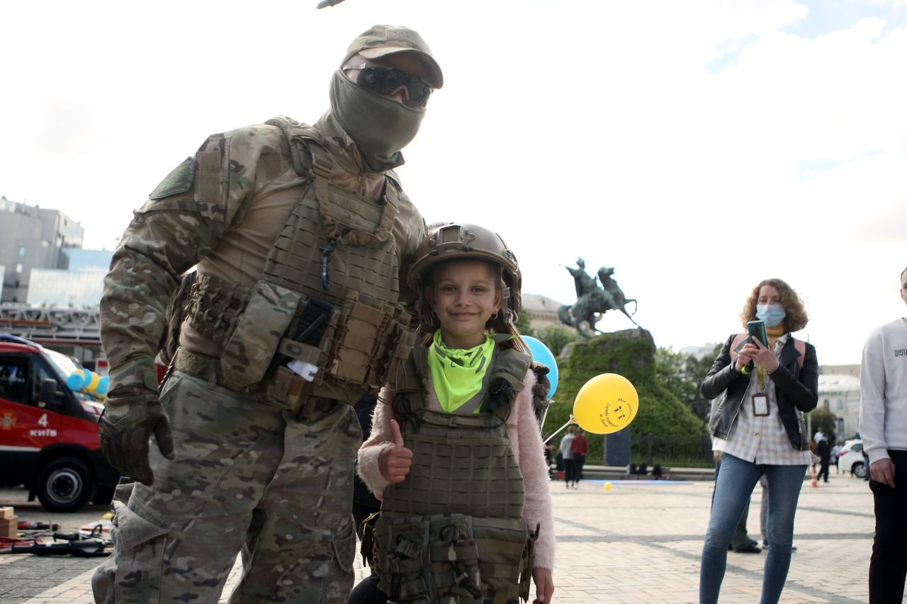 Żołnierz z dziewczynką ubrani w kamizelki kuloodporne. 
