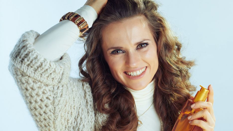 smiling modern woman with hair care productsmiling modern woman with long wavy hair in neck sweater and cardigan with hair care product against winter light blue background.woman, conditioner, isolated, haircare, golden, cold, housewife, winter, cosmetics, vitamins, hair, season, dandruff, applying, older, General, white, texture, knitwear, hairstyles, static, fun, fit, clothes, style, healthy, anti-dandruff, lady, therapy, snow, jumper, product, thin, wintertime, gorgeous, wife, jersey, cute, casual, professional, care, dryness, wavy, one, garment, model, middle aged, moisturizing, light, breakage