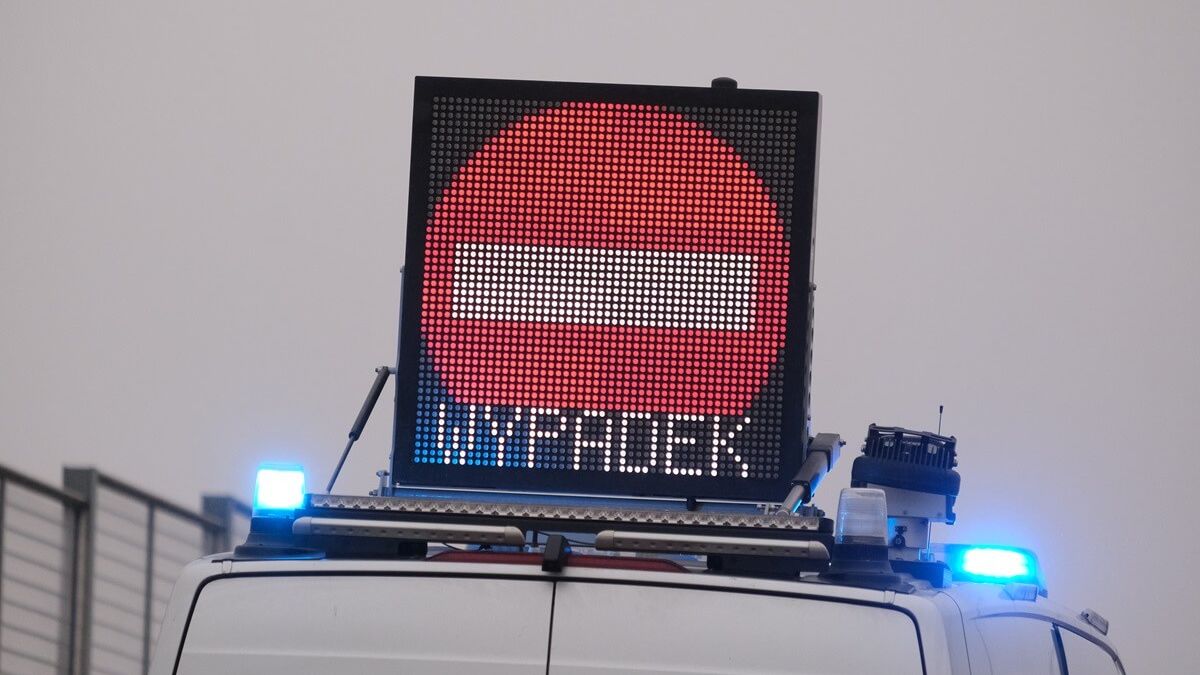 Policyjny radiowóz z tablicą informacyjną "Uwaga Wypadek"