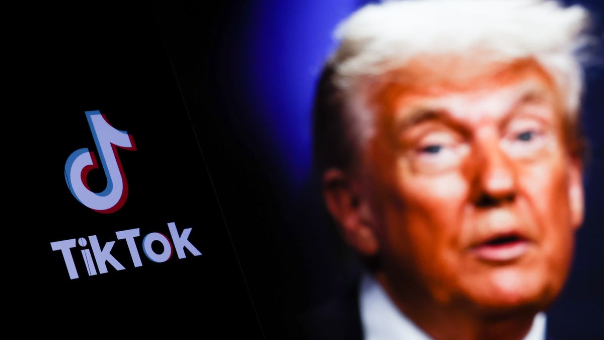TikTok logo displayed on a phone screen and photo of Donald Trump taken on June 25 in The Hague displayed on a laptop screen in the background are seen in this illustration photo taken in Poland on July 21, 2025. (Photo by Jakub Porzycki/NurPhoto via Getty Images)