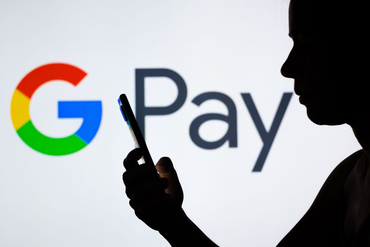 BRAZIL - 2022/04/21: In this photo illustration the Google Pay logo seen in the background of a silhouetted woman holding a mobile phone. (Photo Illustration by Rafael Henrique/SOPA Images/LightRocket via Getty Images)