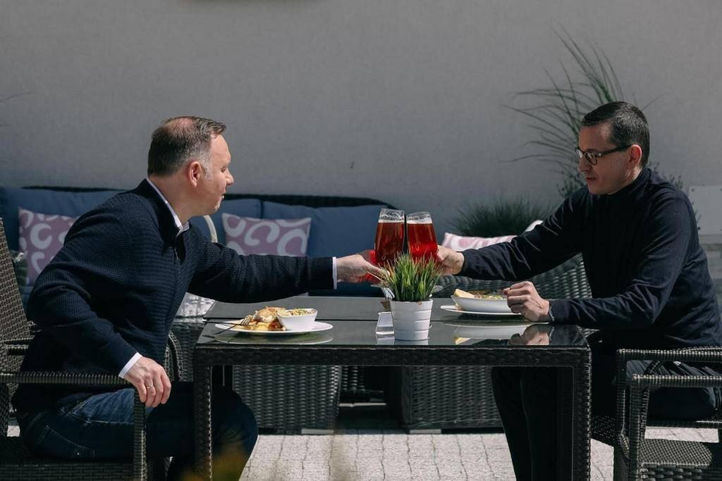 Duda i Morawiecki popijają piwo z sokiem nad morzem