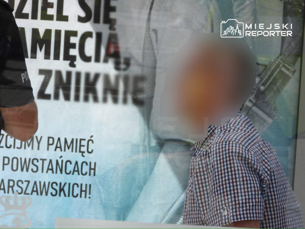 Mężczyzna w koszuli w kratę stoi przed transparentem z napisem "Pamięć o Powstańcach Warszawskich".