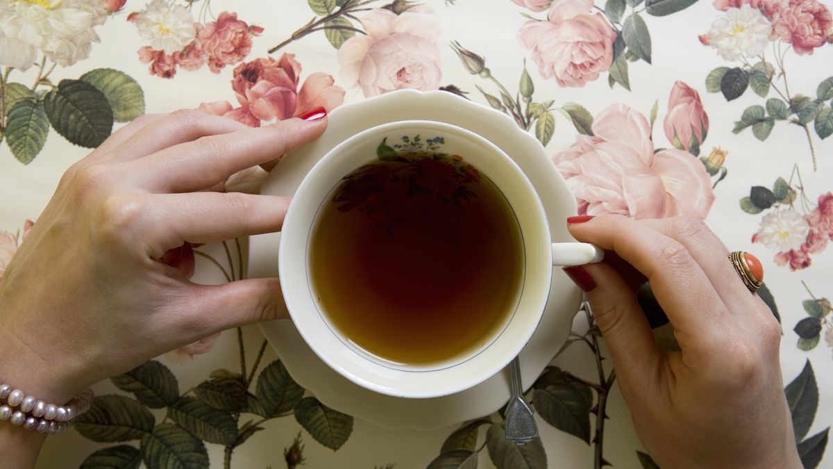 A woman drinking a cup of teaSergeHorizontal, One Person, Unknown, Indoors, Day, High Angle View, Close-Up, One Woman Only, Unrecognizable Person, Human Hand, Holding, Red, Nail Varnish, Tea, Drink, Food And Drink, Refreshment, Cup, Saucer, Spoon, Floral Pattern, Tablecloth, Table, Rose, Design, Kitsch, Afternoon Tea, Leaf, Flower, Pink, White, Elegance, Tea Cup, Domestic Life, Lifestyles, Old Fashioned, Tea Party, 20Th Century Style, British Culture, English Culture, Crockery, Black Tea, Non-Alcoholic Beverage, Traditional Culture, Decor, Hot Drink, Two Objects, Bracelet, Pearl, Ring, High Society, Things That Go Together, Color, Photography