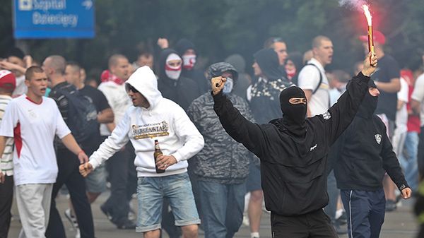 Zamaskowany mężczyzna z racą w trakcie starć na moście Poniatowskiego