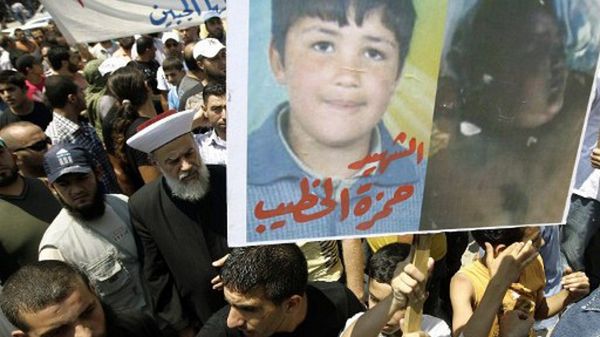 Protestujący w Libanie trzymają zdjęcie Hamzy al-Khatiba
