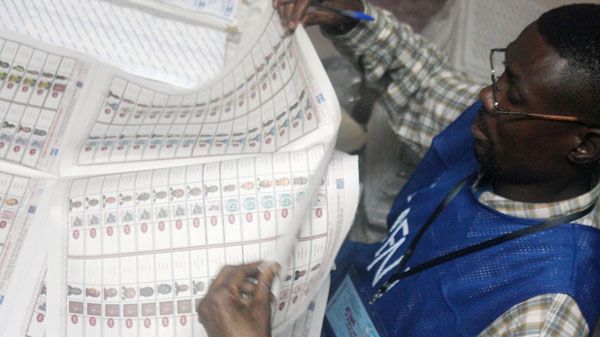 Członek komisji wyborczej sprawdza karty do głosowania