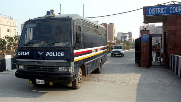 Oskarżeni opuszczają w policyjnym samochodzie teren sądu w Delhi