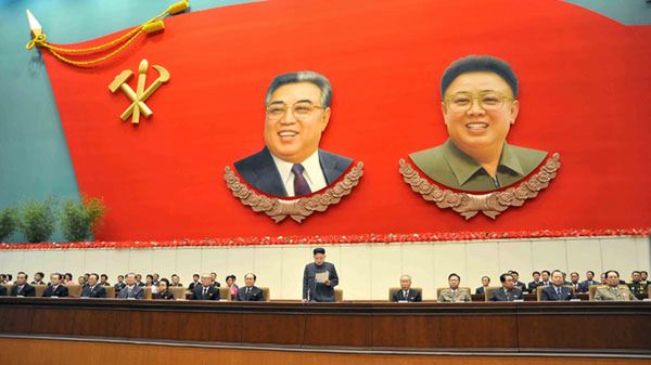 Kim Dzong Un przemawia na tle portretów dziadka - Kim Ir Sena (L) i ojca - Kim Dzong Ila (P)