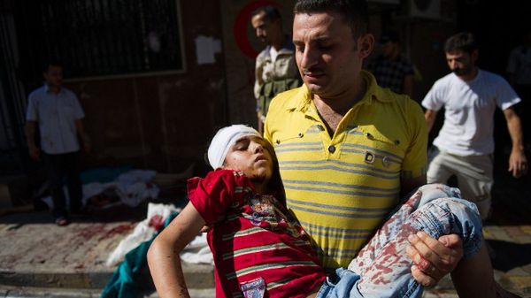 Mężczyzna niesie chłopca rannego podczas ostrzału w pobliżu piekarni w Aleppo, sierpień 2012 r.