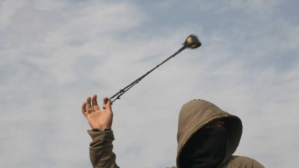 Palestyńczycy często do ataków używają kamieni. Na zdjęciu Palestyńczyk celujący w izraelskich żołnierzy podczas demonstracji w Beit Omar, 2012 r.
