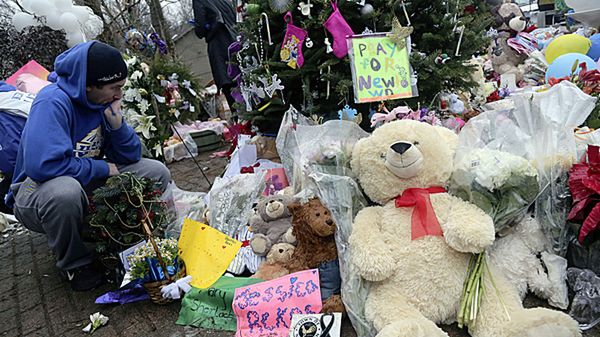 Znicze i maskotki przed budynkiem szkoły w Newtown