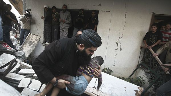 Palestyński sanitariusz niesie martwe ciało chłopca. Dziecko zginęło w wyniku nalotu na Gazę