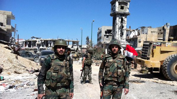 Żołnierze w centrum Al-Kusajr (w tle wieża zegarowa z flagą syryjską zatkniętą na znak zwycięstwa)