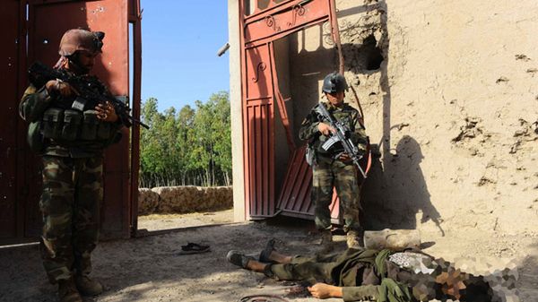 Afgańscy komandosi obok zabitego taliba