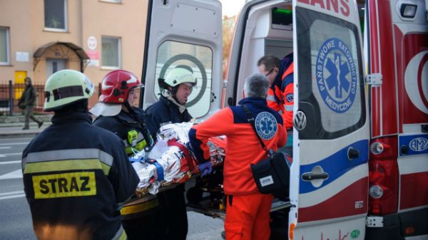 Strażacy i ratownicy medyczni wynoszą mężczyznę, który podpalił się w sądzie