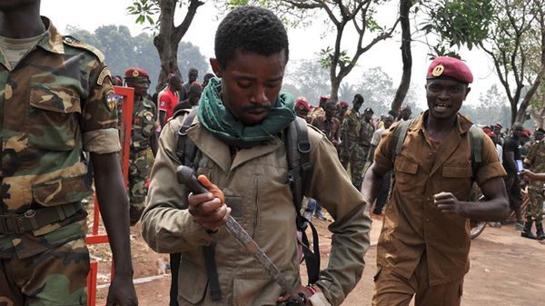 Jeden żołnierzy chowa nóż po tym, jak wziął udział w linczu
