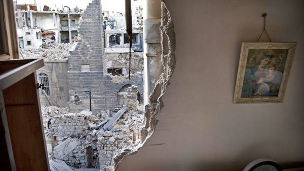 Zniszczone mieszkanie chrześcijańskiej rodziny z Hims, w tle - zrujnowana dzielnica miasta