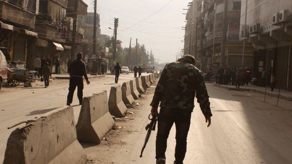 Syryjski rebeliant idzie ulicą Aleppo
