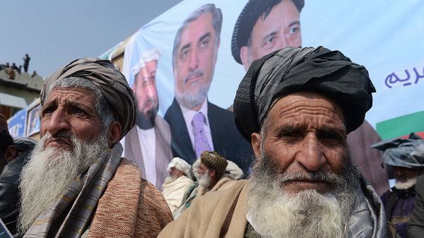 Zwolennicy Abdullaha Abdullaha (widoczny w centrum na plakacie) słuchają jego przemówienia. To jeden z faworytów w wyborach prezydenckich